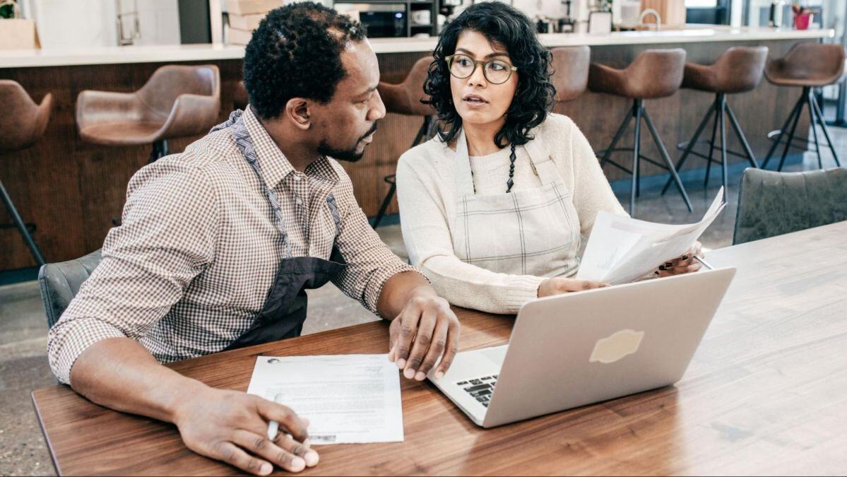 Man and woman discussing strategies to reduce food costs in multi-location restaurants